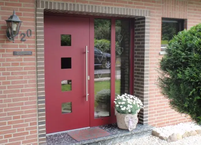 Rote Design-Haustür mit Lichtausschnitten und Glas-Seitenteil, montiert von Metallbau Hendricks